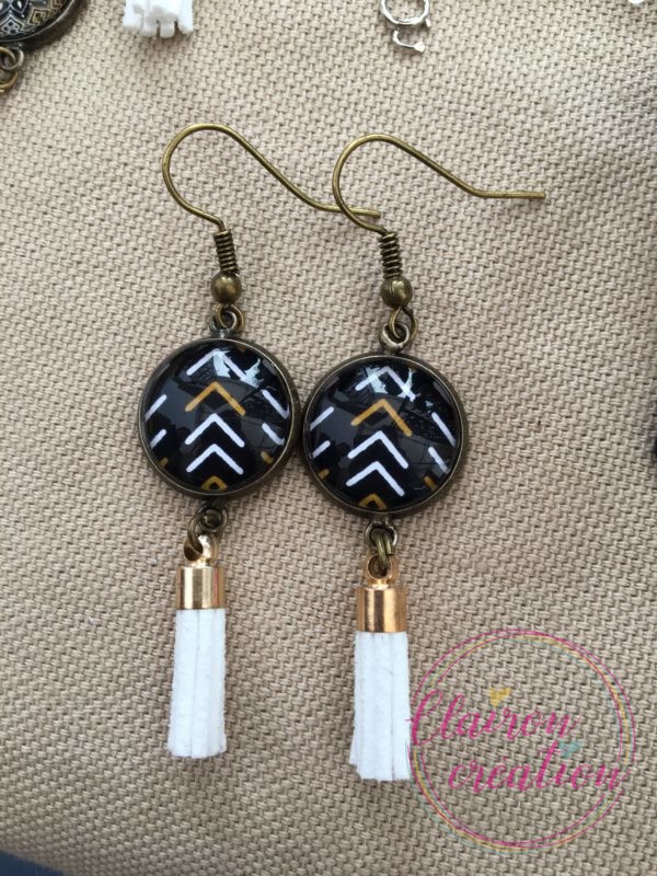Boucles pompon fleches blanc or fond noir